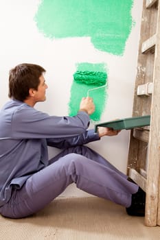 A professional painter painting with a large roller brush