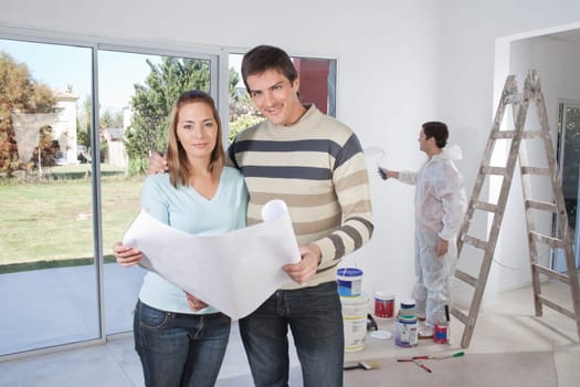 Portrait of happy couple smiling with painter in background