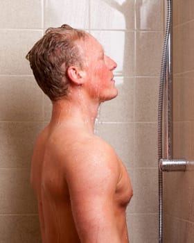 A man standing in a shower with water on face