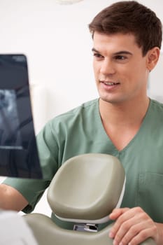 Young male dentist looking at an x-ray