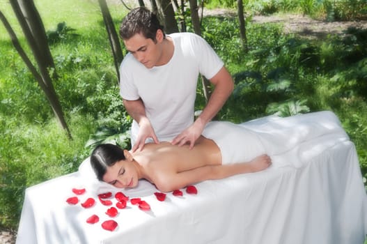 Beautiful woman getting massage and spa treatment in natural setting