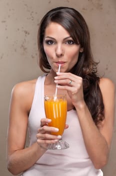 Portrait of pretty young woman drinking orange juice