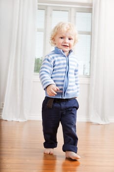 Full length of cute little boy walking on floor at home