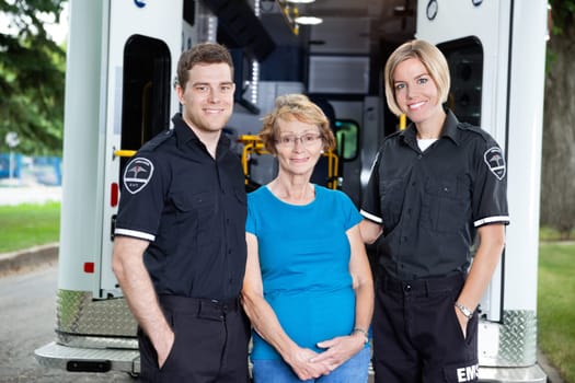 Two Ambulance workers wtanding with patient