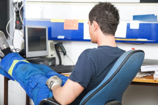 Mechanic sitting at desk in auto repair shop
