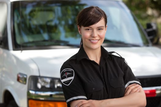 Portrait of a happy confident woman paramedic standing in front of ambulance