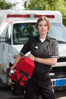 Portrait of an EMS professional carrying a protable oxygen unit