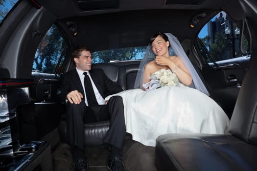 Bride and bridegroom in a luxury wedding limousine