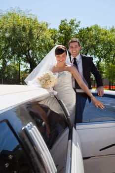 Cheerful newly wed couple getting in the car