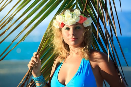 Woman in flower diadem on the beach