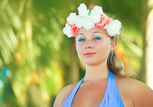 Woman in flower diadem on the beach