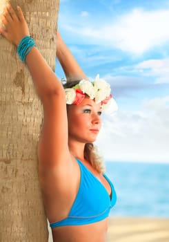 Woman is posing near the trunk at the beach