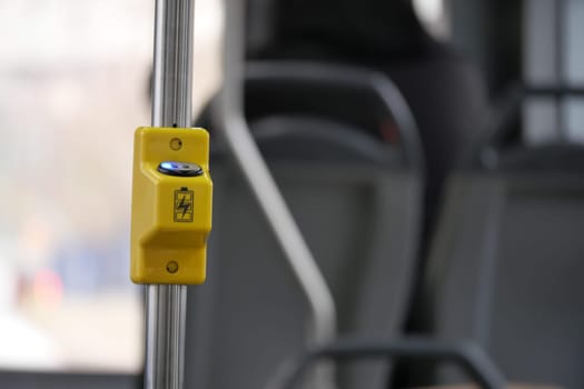 Yellow stop button on bus pole, ensuring passenger safety and convenience.