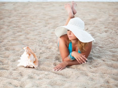 Young woman sunbathing on the tropical beach
