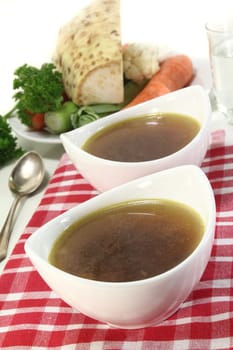 two bowls of beef consommé on a napkin
