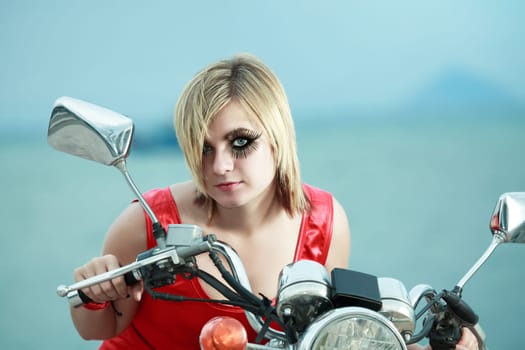 Fashion photo of young woman with a motorcycle