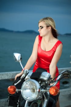 Fashion photo of young woman with a motorcycle