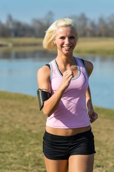 Young woman jogging recreational running by river sunny day