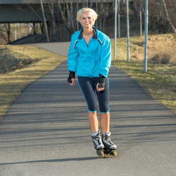Happy woman roller skating sport smiling in park sunny day