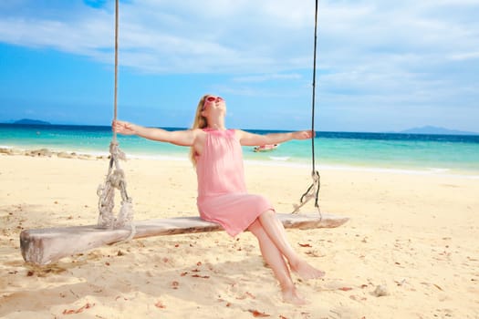 Beautiful woman has fun on the swing