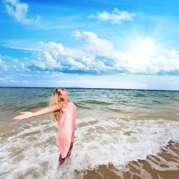 Happy woman with opened hands on the beach