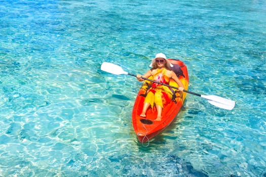 Young woman is Kayaking in tropical lagoon