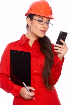 Female architect holding clipboard, using cell phone