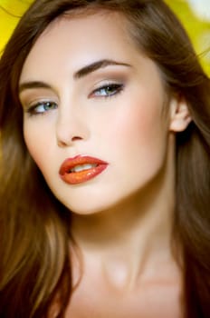 Portrait of beautiful young sexy woman on yellow background
