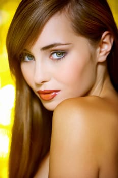 Portrait of beautiful young sexy woman on yellow background