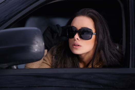 Beautiful woman in car in snowy winter outdoors