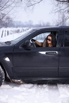 Beautiful woman in car in snowy winter outdoors