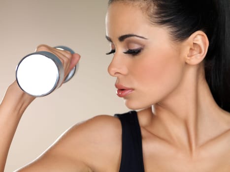 Young beautiful woman during fitness time with dumbbells