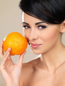 Portrait of beautiful woman, she holding fresh orange