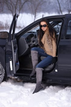 Beautiful woman in car in snowy winter outdoors