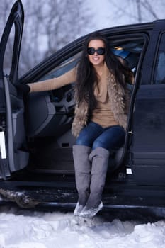 Beautiful woman in car in snowy winter outdoors