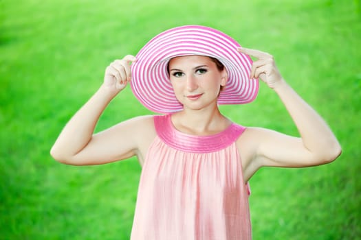 Portrait of the beautiful woman over natural green background