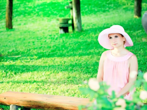 Beautiful woman is sitting in a tropical garden