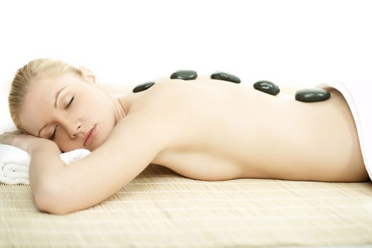 Young blond woman getting lastone treatment at spa