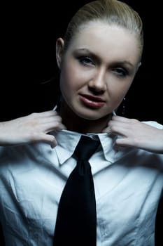 Beautiful business woman wearing black tie and white shirt isolated on black background