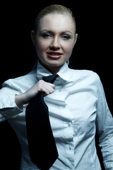 Beautiful business woman wearing black tie and white shirt isolated on black background