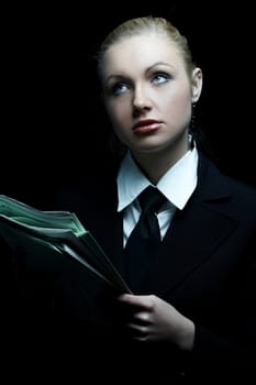 Beautiful business woman wearing black tie and jacket isolated on black background holding newspaper