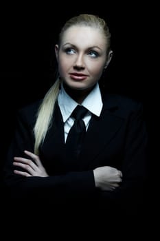 Beautiful business woman wearing black tie and jacket isolated on black background