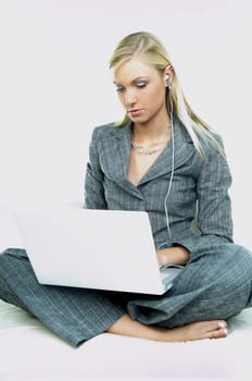 Portrait of a businesswoman working on laptop computer and listen to music