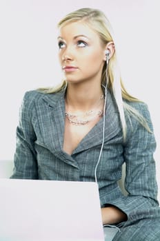 Portrait of a businesswoman working on laptop computer and listen to music