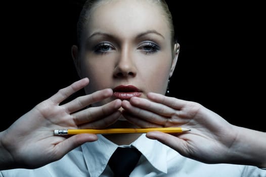 Beautiful business woman wearing black tie and white shirt isolated on black background holding pencil