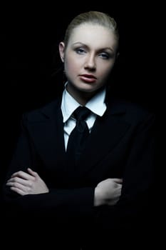 Beautiful business woman wearing black tie and jacket isolated on black background
