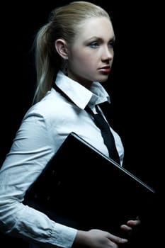 Beautiful business woman wearing black tie and white shirt holding folder isolated on black background