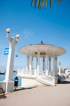 The white concrete gazebo in marine near the sea