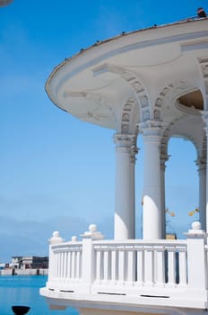 The white concrete gazebo in marine near the sea