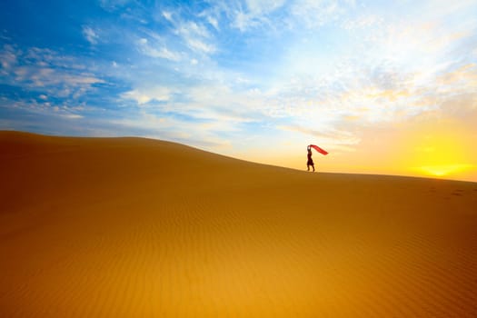Beautiful woman with red showl in desert